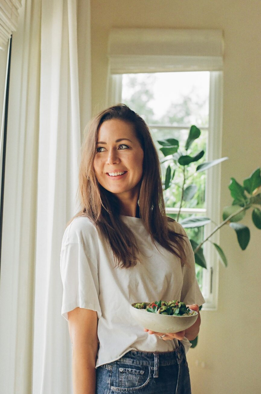 camille styles smiling holding bowl of marinated olives