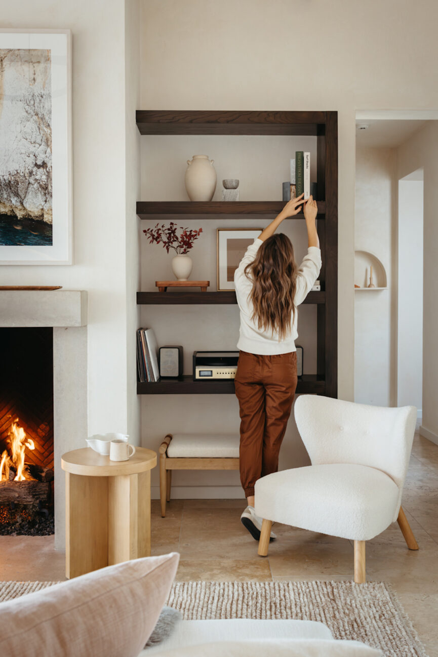 Woman styling bookshelves