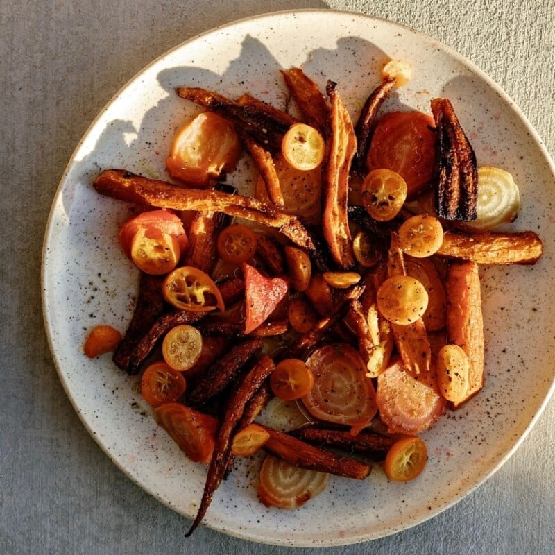 Carrot kumquat golden beet salad served on white plate.