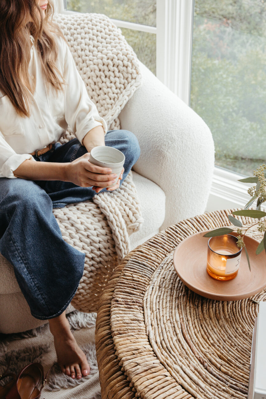 Camille Styles sitting by a coffee table