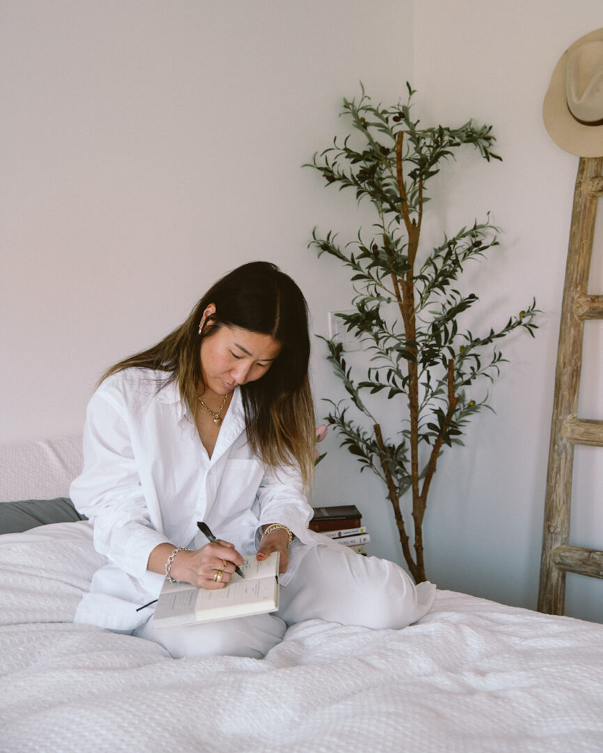 Woman journaling in bed.