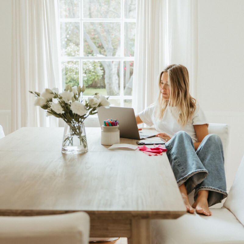 Woman on computer browsing editor spring fashion trends.