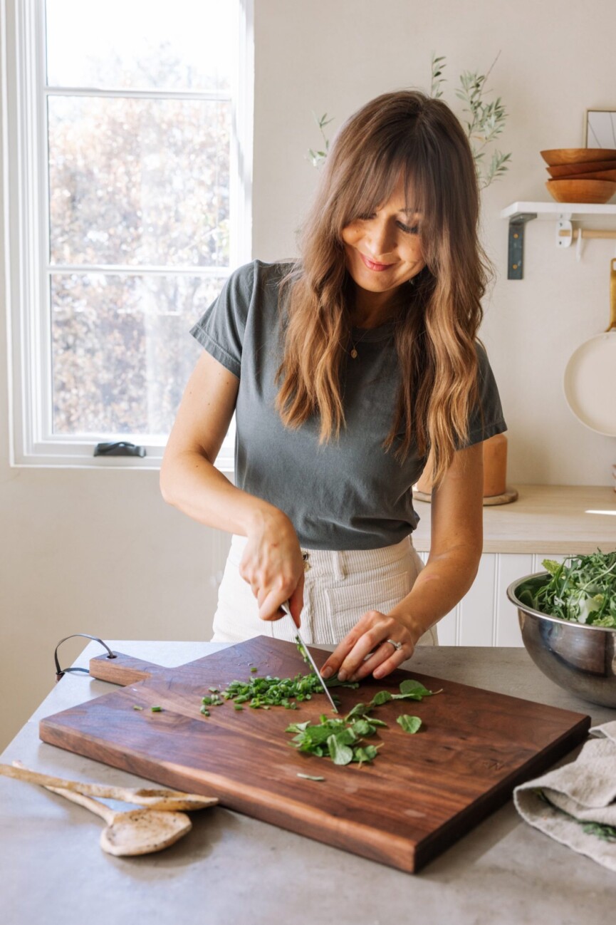 Woman chopping salad greens.