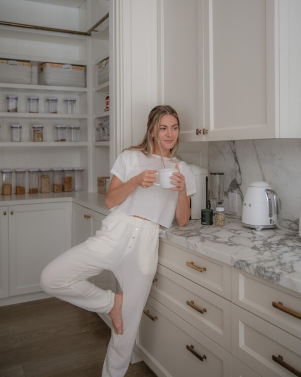 Woman drinking coffee in kitchen.